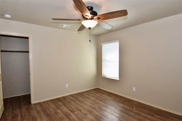 unfurnished bedroom with dark hardwood / wood-style floors, ceiling fan, and a closet