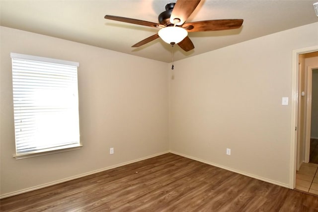 spare room featuring dark wood-type flooring and ceiling fan