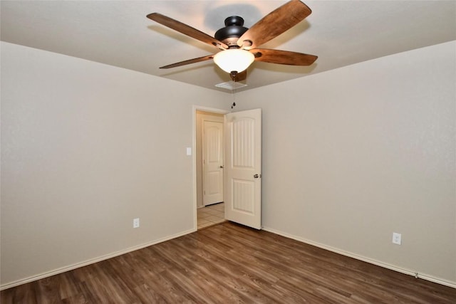 spare room featuring dark hardwood / wood-style floors and ceiling fan