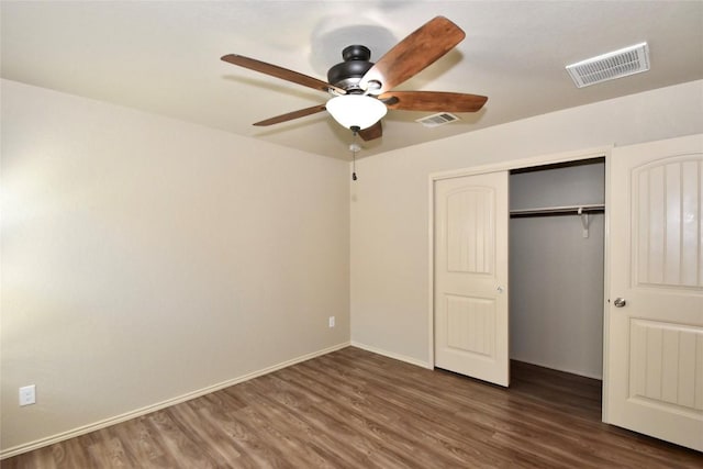 unfurnished bedroom with dark hardwood / wood-style floors, ceiling fan, and a closet