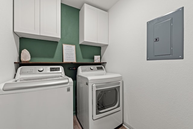 washroom featuring washer and clothes dryer, electric panel, and cabinets