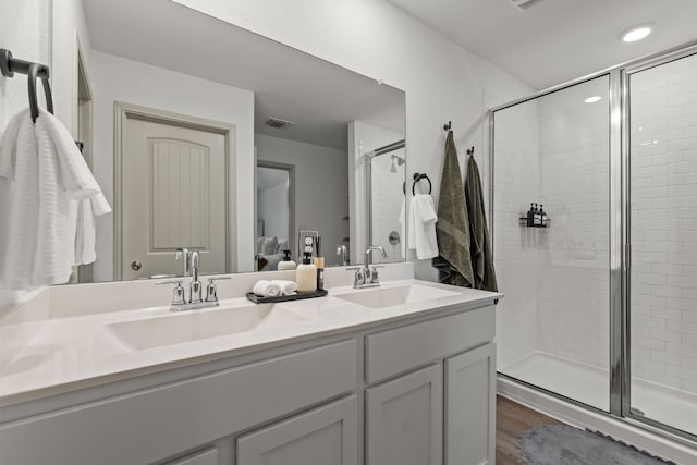 bathroom featuring vanity, hardwood / wood-style flooring, and a shower with shower door