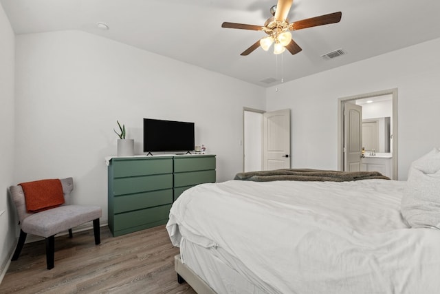 bedroom with ceiling fan, lofted ceiling, connected bathroom, and light hardwood / wood-style floors