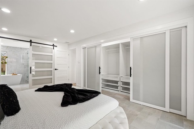 bedroom featuring connected bathroom and a barn door