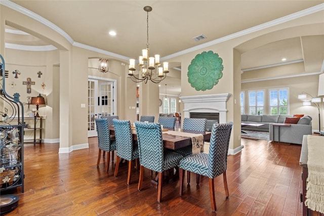 dining space with an inviting chandelier, hardwood / wood-style floors, and ornamental molding