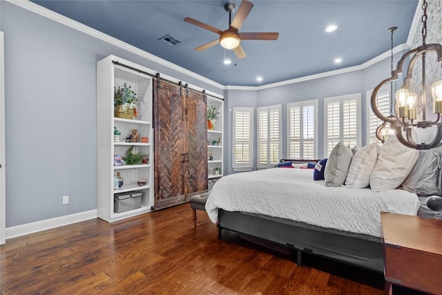 bedroom with dark wood-type flooring, ornamental molding, a barn door, and ceiling fan with notable chandelier