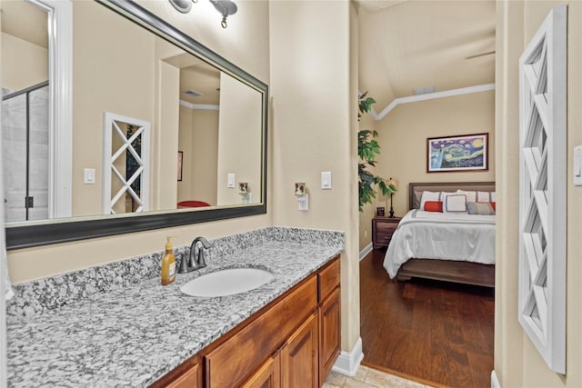 bathroom with vanity, wood-type flooring, ornamental molding, and a shower