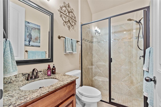 bathroom with vanity, toilet, and a shower with door