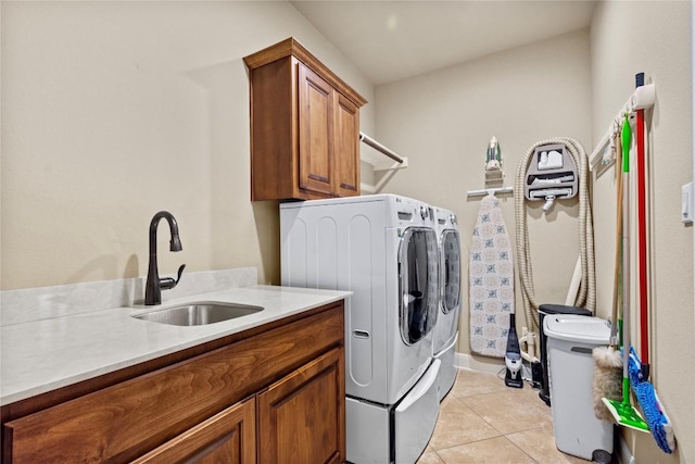 clothes washing area with cabinets, washer and dryer, sink, and light tile patterned floors