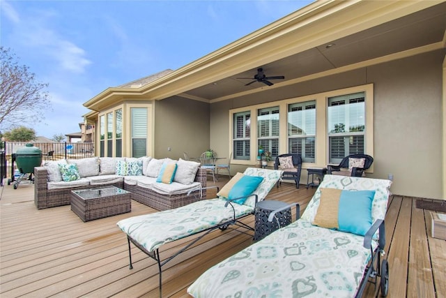 wooden terrace with an outdoor living space and ceiling fan