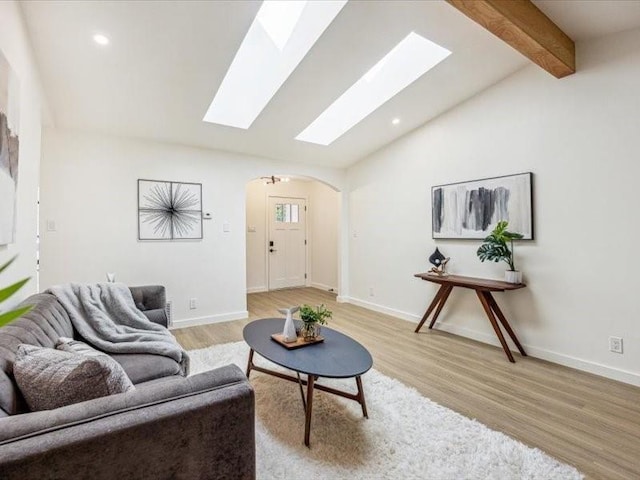 living room with vaulted ceiling with beams and light hardwood / wood-style flooring