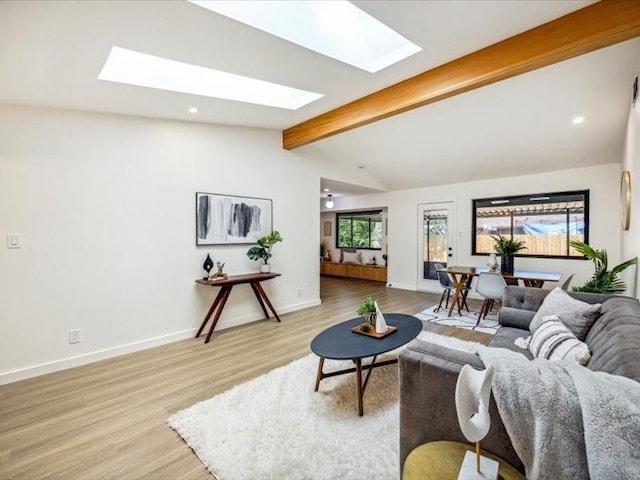 living room with light hardwood / wood-style flooring and lofted ceiling with skylight