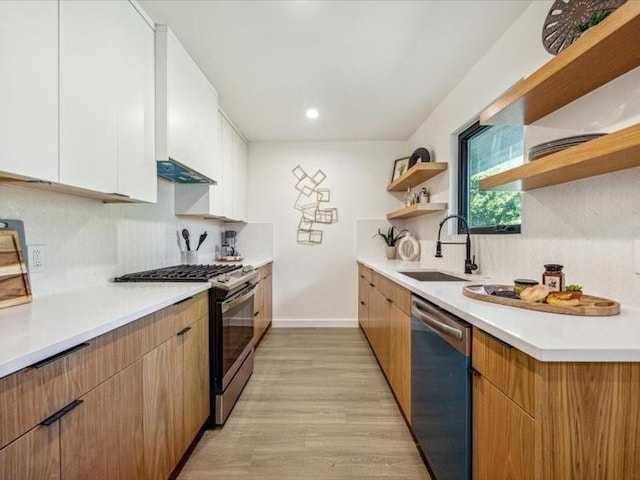 kitchen featuring backsplash, appliances with stainless steel finishes, sink, and white cabinets