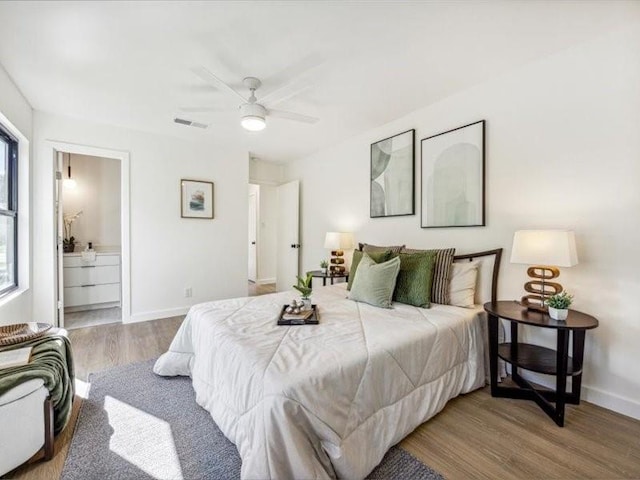 bedroom featuring connected bathroom, hardwood / wood-style flooring, and ceiling fan