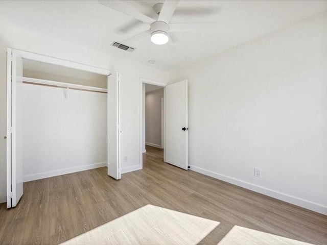 unfurnished bedroom with ceiling fan, a closet, and light wood-type flooring