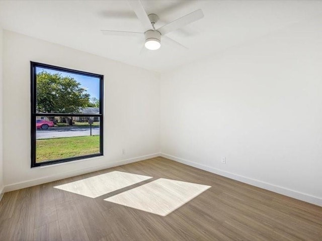 empty room with hardwood / wood-style floors and ceiling fan