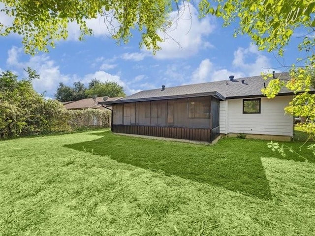 back of house with a sunroom and a lawn