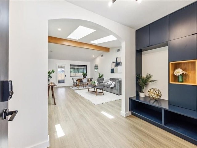 interior space with lofted ceiling with beams and light wood-type flooring