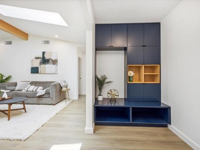 mudroom featuring light hardwood / wood-style flooring and lofted ceiling with skylight