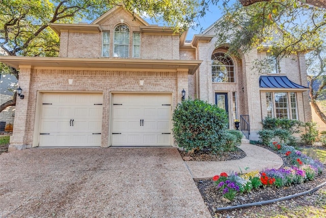 view of front of house featuring a garage, brick siding, and driveway