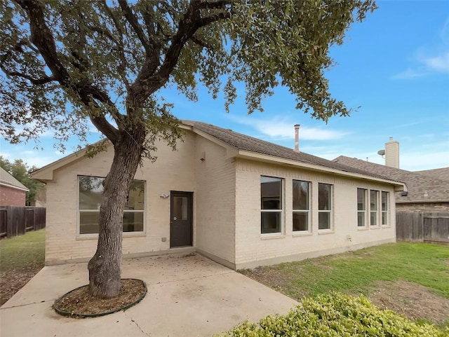 back of property with a patio and a yard