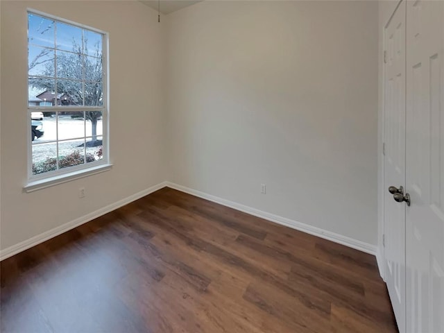 unfurnished room with dark wood-type flooring