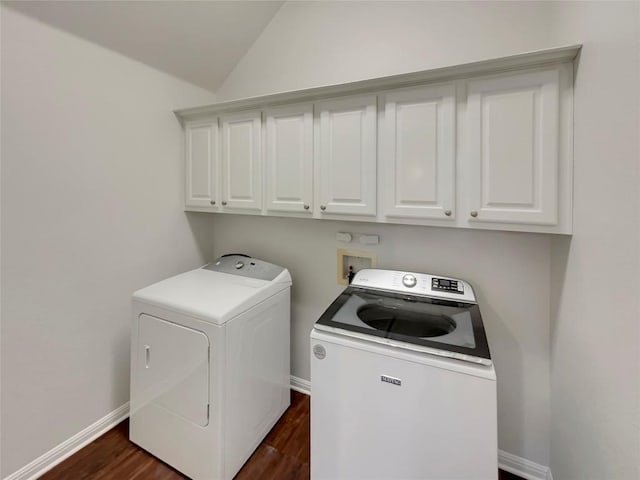 washroom featuring dark hardwood / wood-style floors, washing machine and dryer, and cabinets