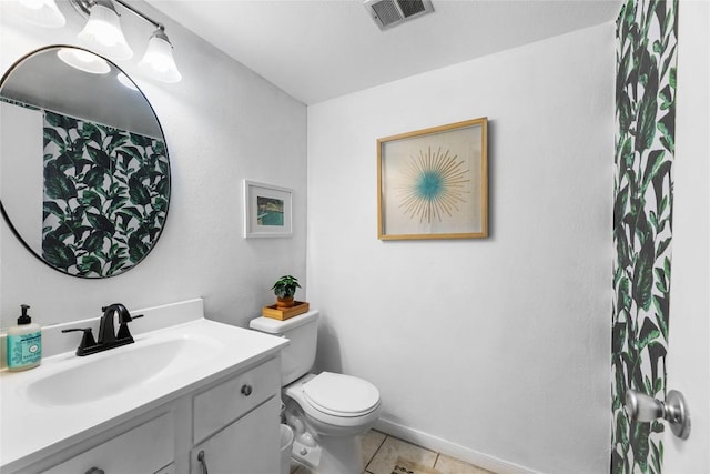 bathroom featuring vanity, toilet, and tile patterned flooring