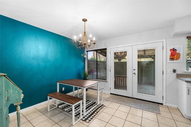 tiled dining room with an inviting chandelier and french doors