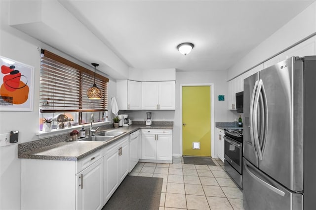 kitchen with appliances with stainless steel finishes, sink, hanging light fixtures, and white cabinets