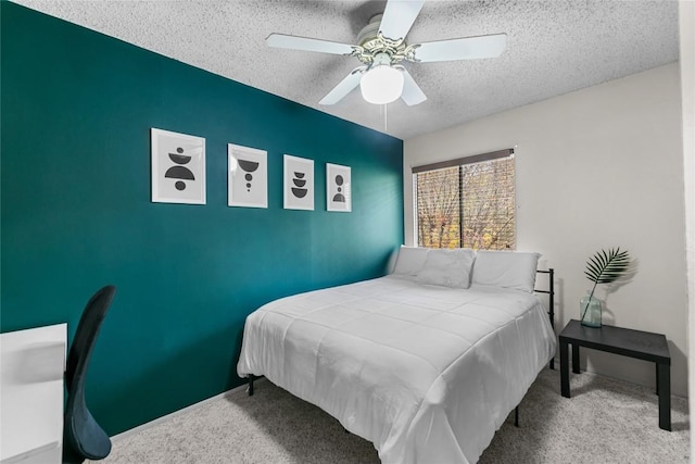 carpeted bedroom featuring ceiling fan and a textured ceiling