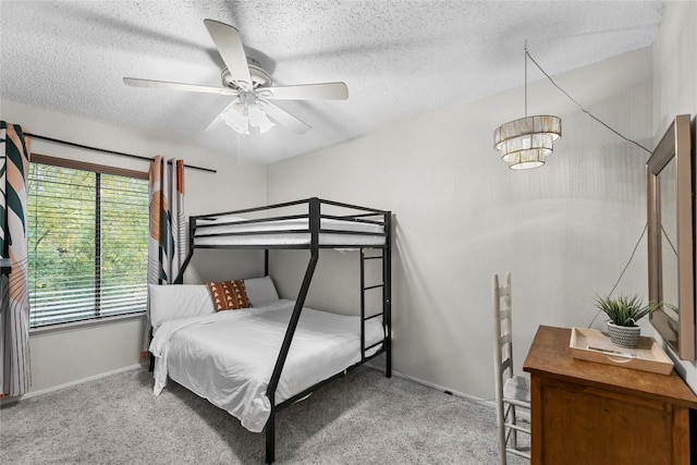 bedroom with ceiling fan, carpet floors, and a textured ceiling