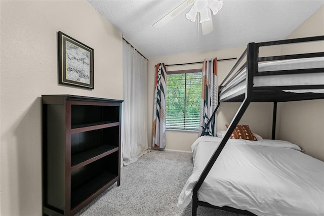 bedroom with light carpet, ceiling fan, and a textured ceiling