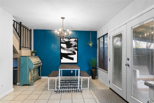 dining space with light tile patterned floors, a notable chandelier, and french doors