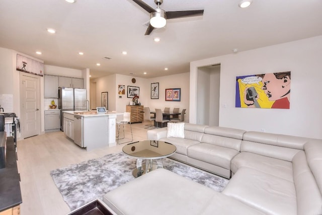 living room with recessed lighting, light wood-style flooring, visible vents, and ceiling fan