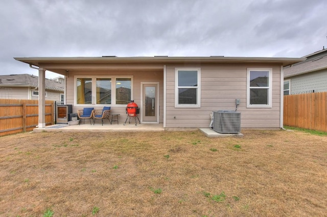 rear view of house with a yard, central AC unit, and a patio