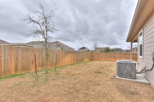 view of yard featuring central AC unit and a fenced backyard