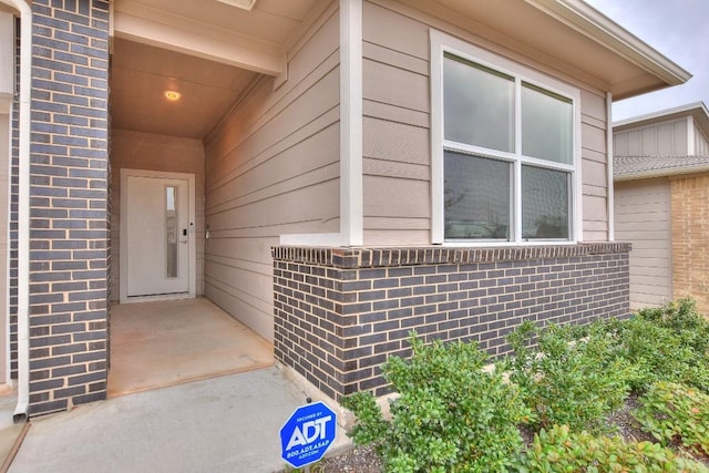 view of exterior entry with brick siding