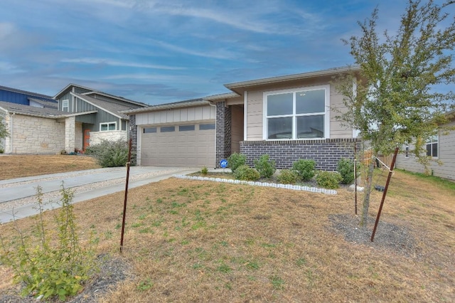 view of front of home with brick siding, a garage, a front lawn, and driveway