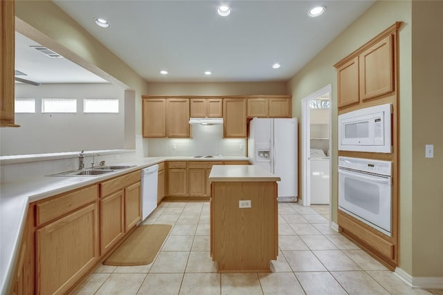 kitchen with sink, white appliances, light tile patterned floors, a center island, and washer / dryer