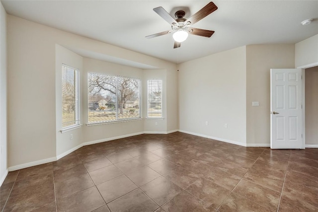 empty room featuring tile patterned floors and ceiling fan