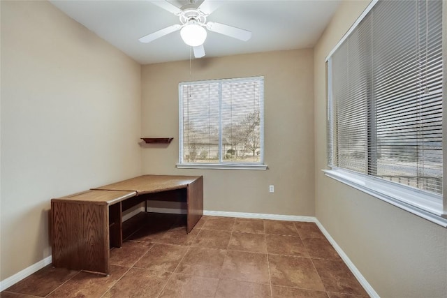 unfurnished office featuring a wealth of natural light, tile patterned floors, and ceiling fan