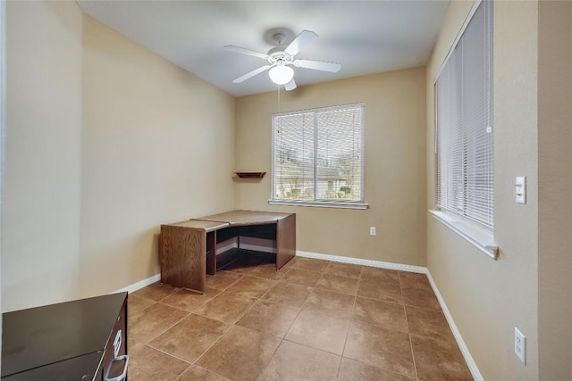 unfurnished office with ceiling fan and tile patterned floors