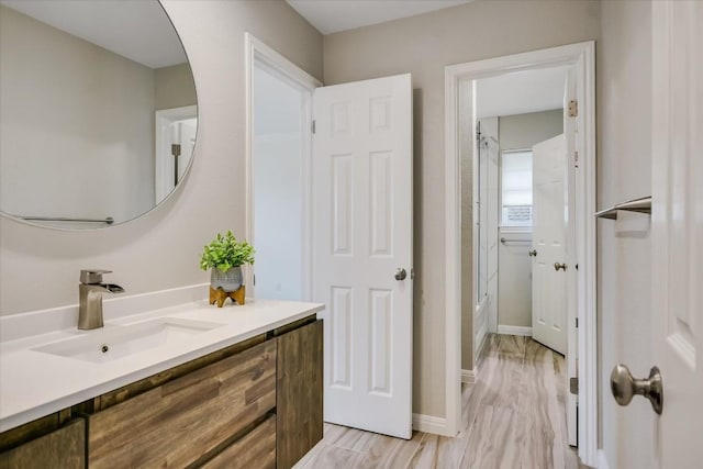 bathroom with shower / bath combination, vanity, and wood-type flooring