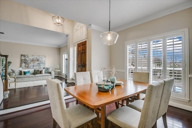 dining area featuring dark hardwood / wood-style flooring, a wealth of natural light, and ornamental molding