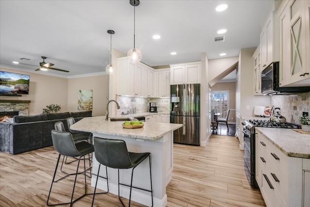 kitchen featuring pendant lighting, white cabinetry, range with two ovens, kitchen peninsula, and stainless steel refrigerator with ice dispenser