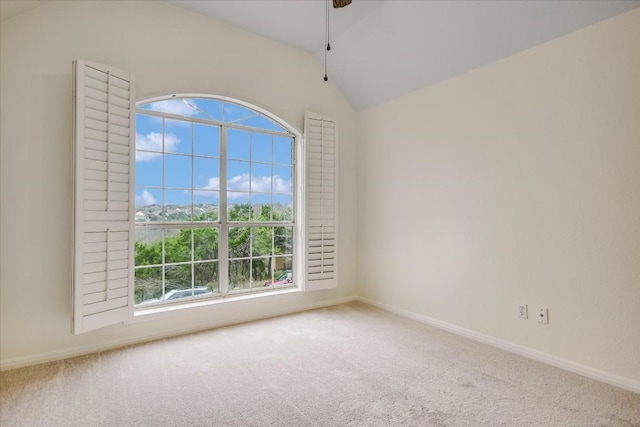 carpeted empty room featuring vaulted ceiling and ceiling fan