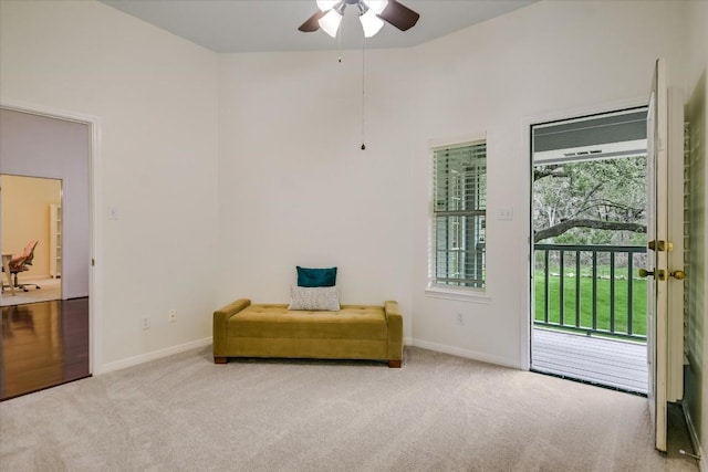 living area with ceiling fan and light carpet