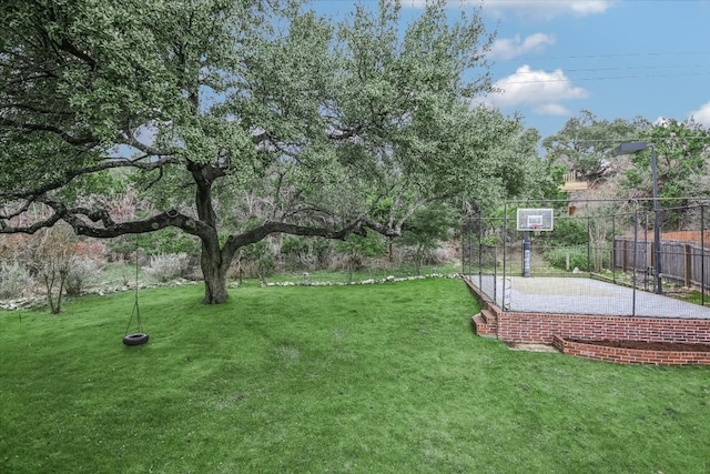 view of yard featuring basketball hoop