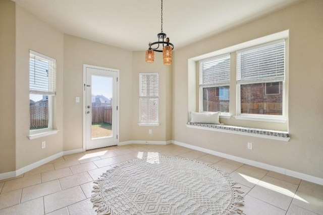 doorway featuring light tile patterned flooring and an inviting chandelier